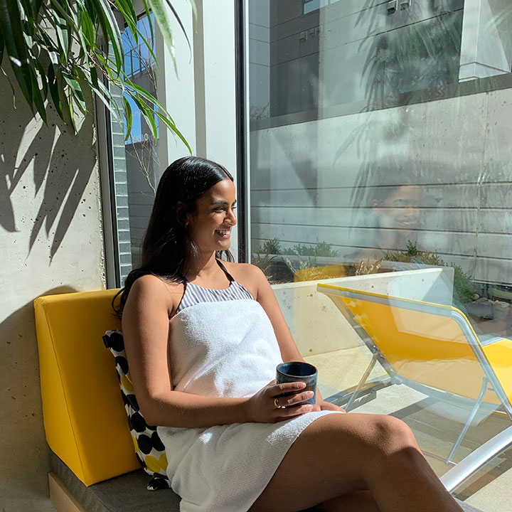 Woman basking in the sun of her private suite at Ritual Nordic Spa